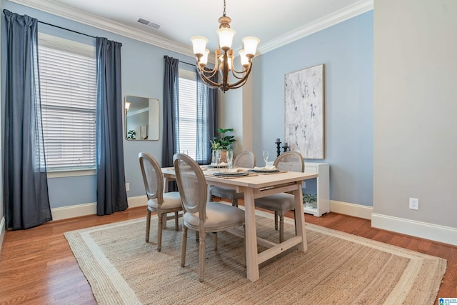 dining area with ornamental molding, a wealth of natural light, and a notable chandelier