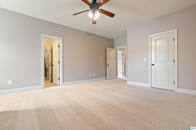 unfurnished bedroom featuring light carpet, ensuite bath, and ceiling fan