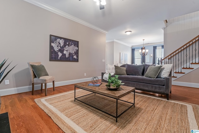 living room with hardwood / wood-style flooring, crown molding, and ceiling fan with notable chandelier