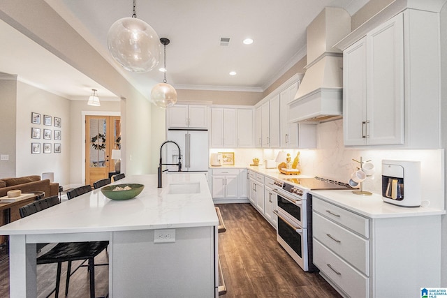 kitchen featuring a breakfast bar area, white appliances, white cabinetry, a center island with sink, and custom range hood