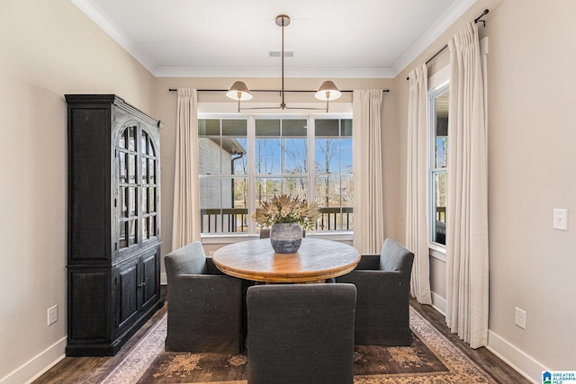 dining room featuring ornamental molding, dark wood finished floors, visible vents, and baseboards