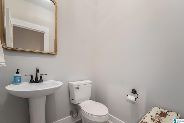 bathroom with toilet and baseboards