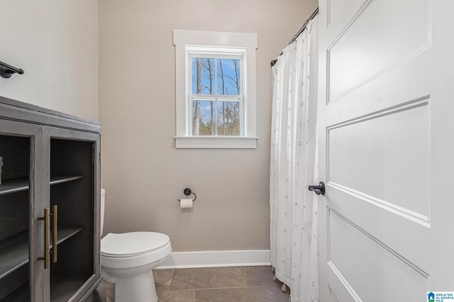 full bathroom featuring toilet, tile patterned flooring, and baseboards