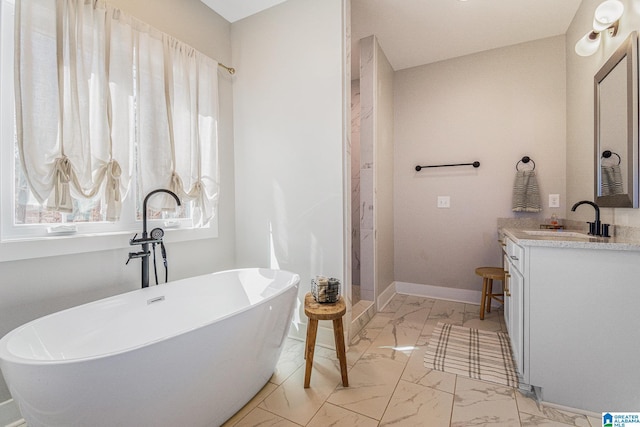 full bath featuring marble finish floor, vanity, baseboards, and a soaking tub