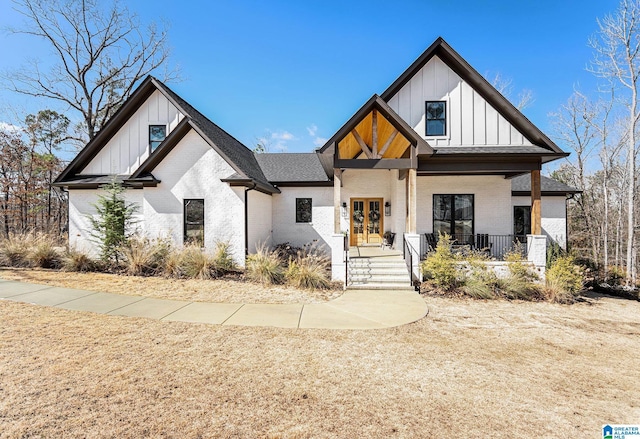 modern farmhouse style home featuring french doors, brick siding, a porch, a shingled roof, and board and batten siding