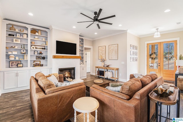 living room with recessed lighting, crown molding, dark wood-style flooring, and a lit fireplace