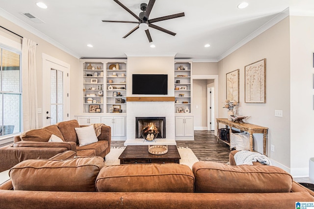 living room featuring dark wood-type flooring, a warm lit fireplace, crown molding, and baseboards