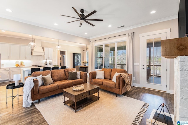 living room featuring recessed lighting, visible vents, baseboards, ornamental molding, and light wood finished floors