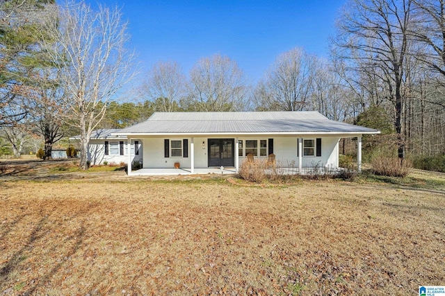 ranch-style home with a porch, metal roof, and a front lawn