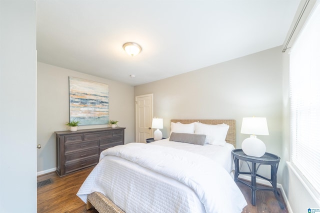 bedroom with dark hardwood / wood-style floors