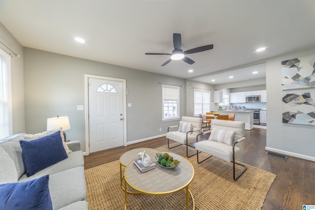 living room featuring dark hardwood / wood-style flooring and ceiling fan