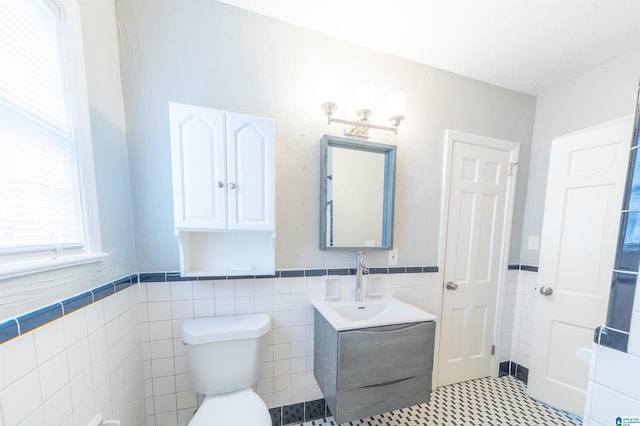 bathroom with tile walls, vanity, and toilet