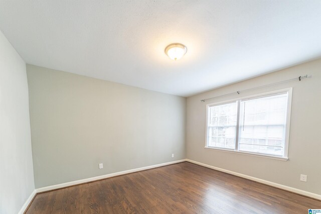 empty room with dark wood-type flooring