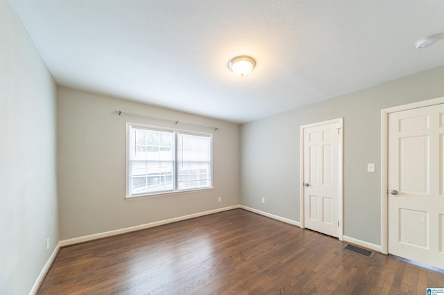 unfurnished bedroom featuring dark hardwood / wood-style flooring