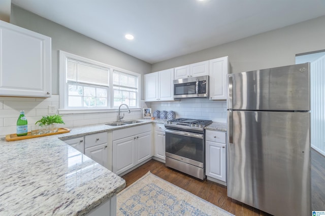 kitchen featuring sink, tasteful backsplash, appliances with stainless steel finishes, light stone countertops, and white cabinets