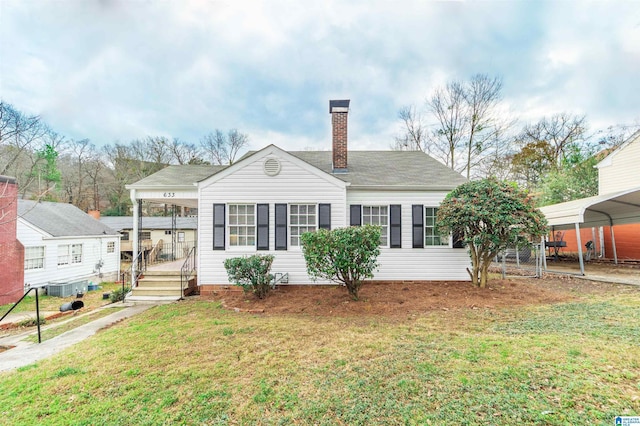 view of front of property with a carport, a front lawn, and central air condition unit