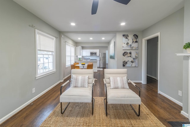 sitting room featuring dark wood-type flooring and ceiling fan