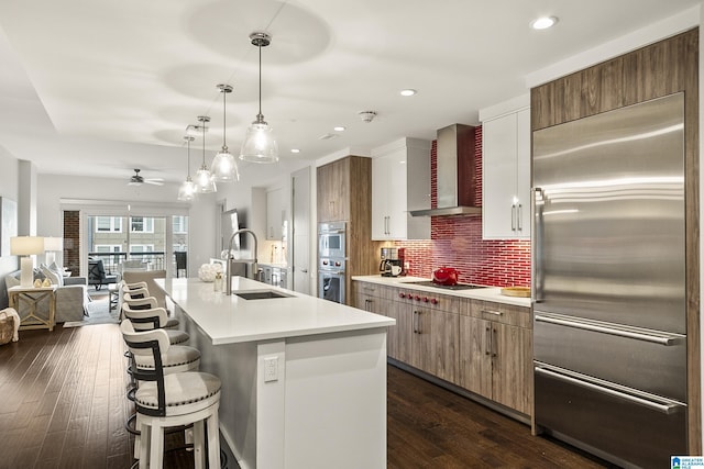 1150 8th St Unit 503, Tuscaloosa, AL 35401 - kitchen with wall chimney exhaust hood, sink, appliances with stainless steel finishes, an island with sink, and backsplash