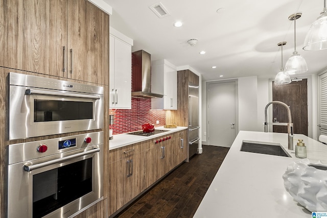 1150 8th St Unit 503, Tuscaloosa, AL 35401 - kitchen featuring white cabinetry, appliances with stainless steel finishes, sink, and wall chimney range hood