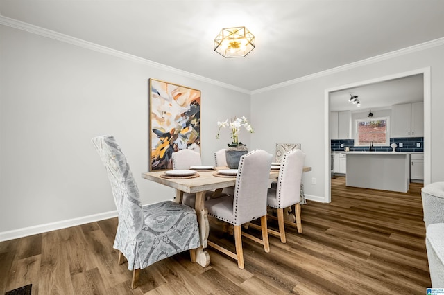 dining space featuring ornamental molding and hardwood / wood-style floors