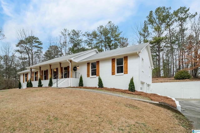 single story home with a front yard and covered porch