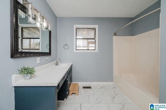 bathroom featuring vanity, a wealth of natural light, and a textured ceiling