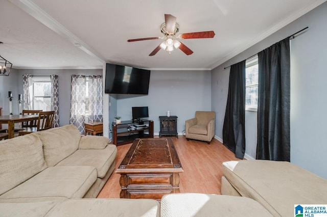 living room featuring crown molding, ceiling fan with notable chandelier, and light hardwood / wood-style floors