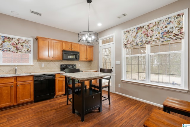 kitchen with dark wood-type flooring, sink, black appliances, hanging light fixtures, and backsplash