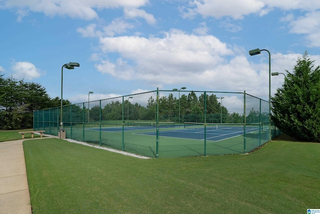 view of tennis court with a yard