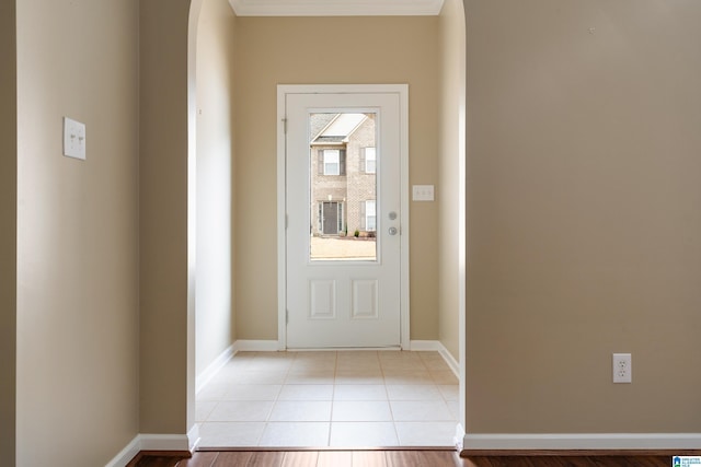 entryway featuring light tile patterned floors and crown molding