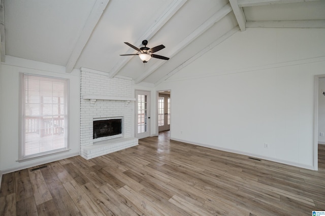 unfurnished living room featuring vaulted ceiling with beams, a fireplace, light hardwood / wood-style floors, and ceiling fan