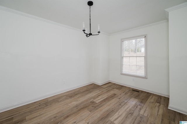 unfurnished room with ornamental molding, a chandelier, and light wood-type flooring