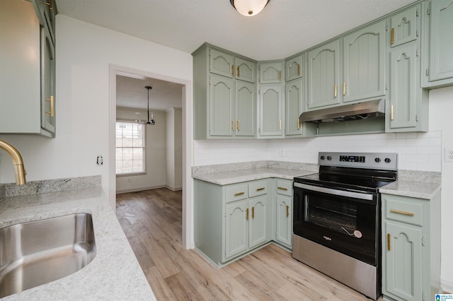 kitchen featuring stainless steel electric stove, sink, green cabinets, and decorative backsplash