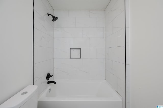 bathroom with tiled shower / bath combo and toilet