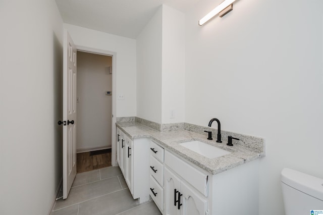 bathroom with vanity, tile patterned flooring, and toilet