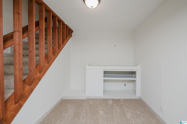 staircase featuring carpet flooring