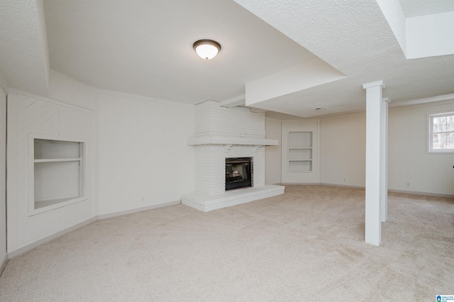 unfurnished living room with a brick fireplace, light colored carpet, built in features, and a textured ceiling