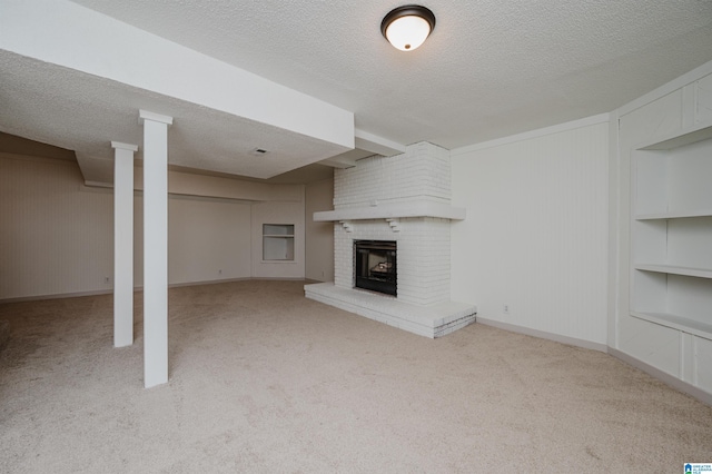 unfurnished living room featuring light colored carpet, a textured ceiling, built in features, and a fireplace