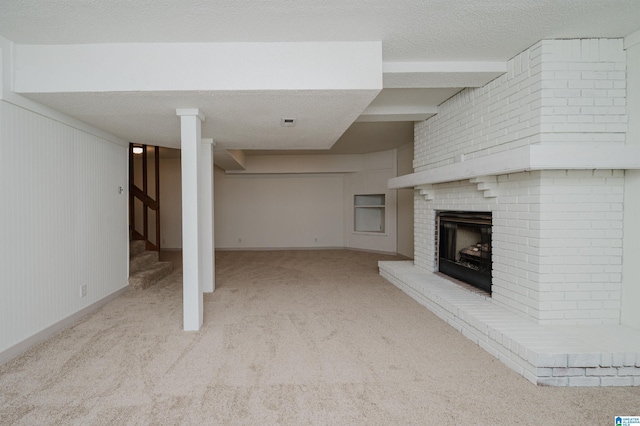 unfurnished living room with a brick fireplace, light carpet, and a textured ceiling