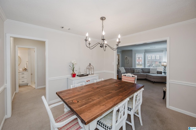 dining area with crown molding, light colored carpet, and a chandelier