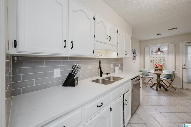 kitchen featuring sink, decorative light fixtures, stainless steel dishwasher, and white cabinets