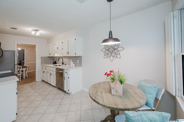 kitchen with sink, hanging light fixtures, white cabinets, stainless steel appliances, and backsplash