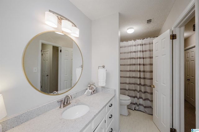 bathroom with vanity, tile patterned flooring, toilet, and a textured ceiling