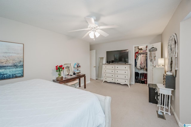 carpeted bedroom featuring ceiling fan and a closet