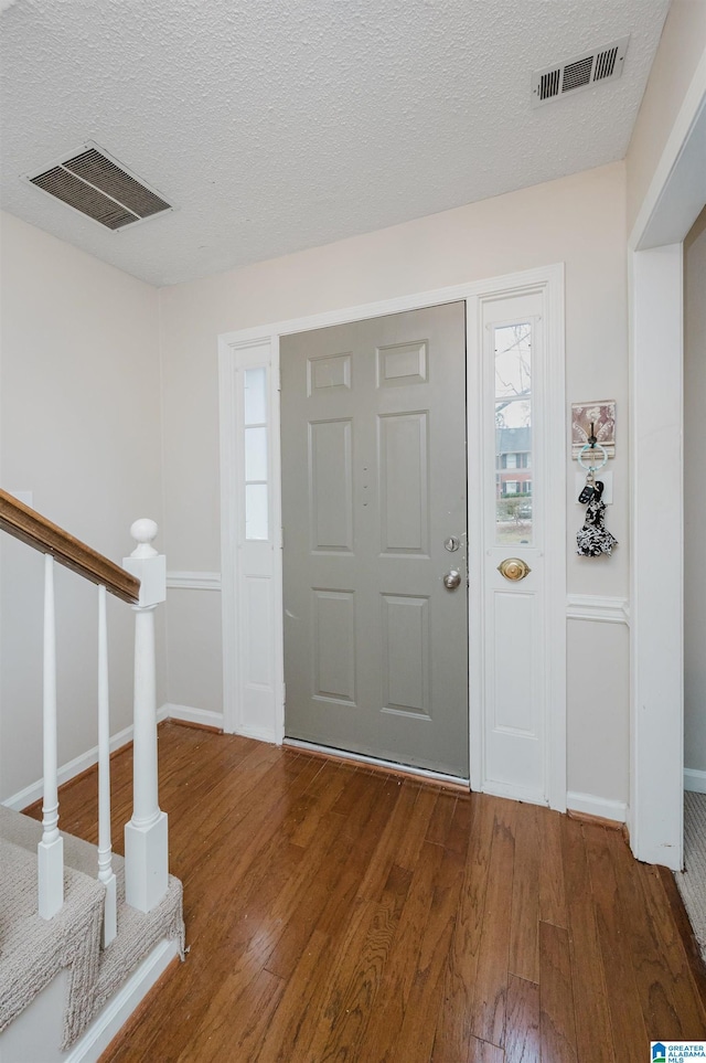 entrance foyer featuring hardwood / wood-style floors and a textured ceiling