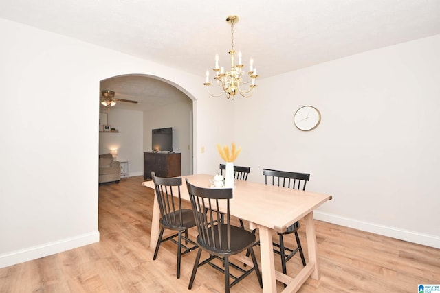 dining area with ceiling fan with notable chandelier and light hardwood / wood-style floors