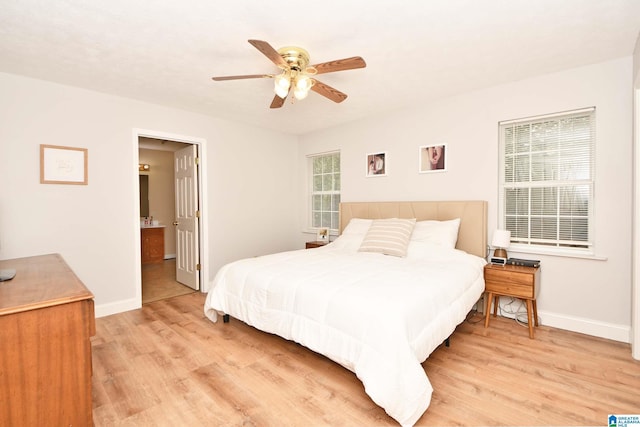 bedroom featuring light hardwood / wood-style floors, ceiling fan, and ensuite bathroom