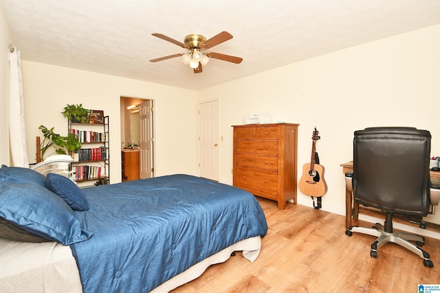 bedroom with ceiling fan, a textured ceiling, and light wood-type flooring