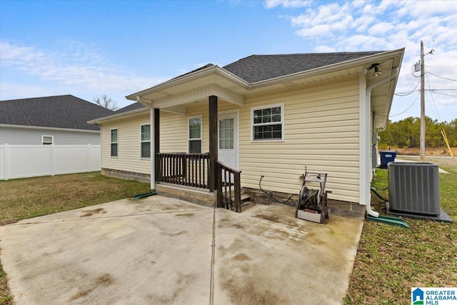 rear view of house with a yard, central AC, and a patio area