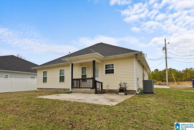 back of property with central AC unit, a yard, and a patio